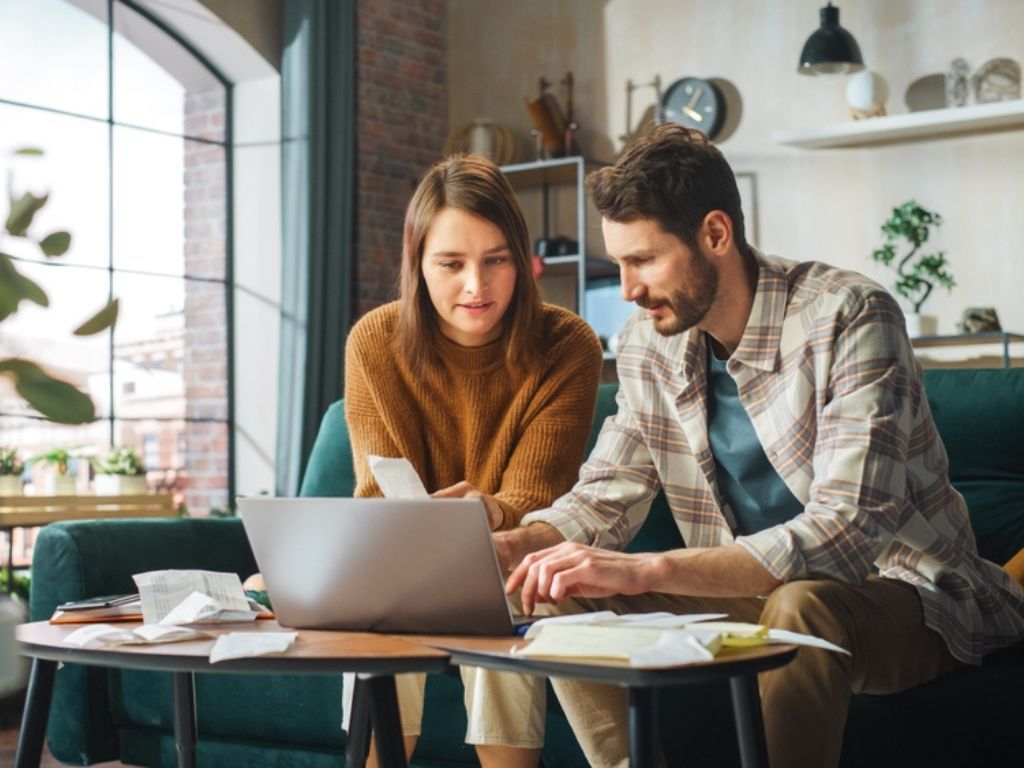 Dos personas trabajan en hacer su operación renta 2025 frente a su computador.